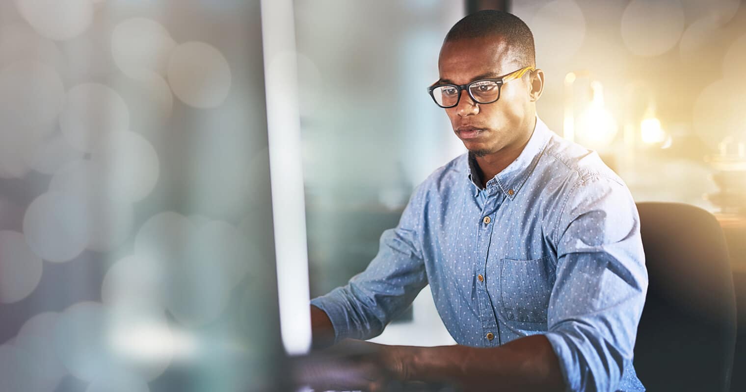 Man working in front of a computer as a representation of the Chief Data Officer's responsibilities.